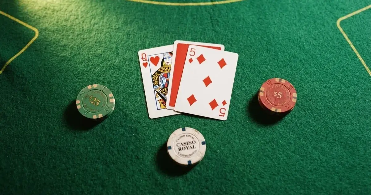 A close-up of a blackjack table felt with cards and chips laid out, no dealer or players visible.